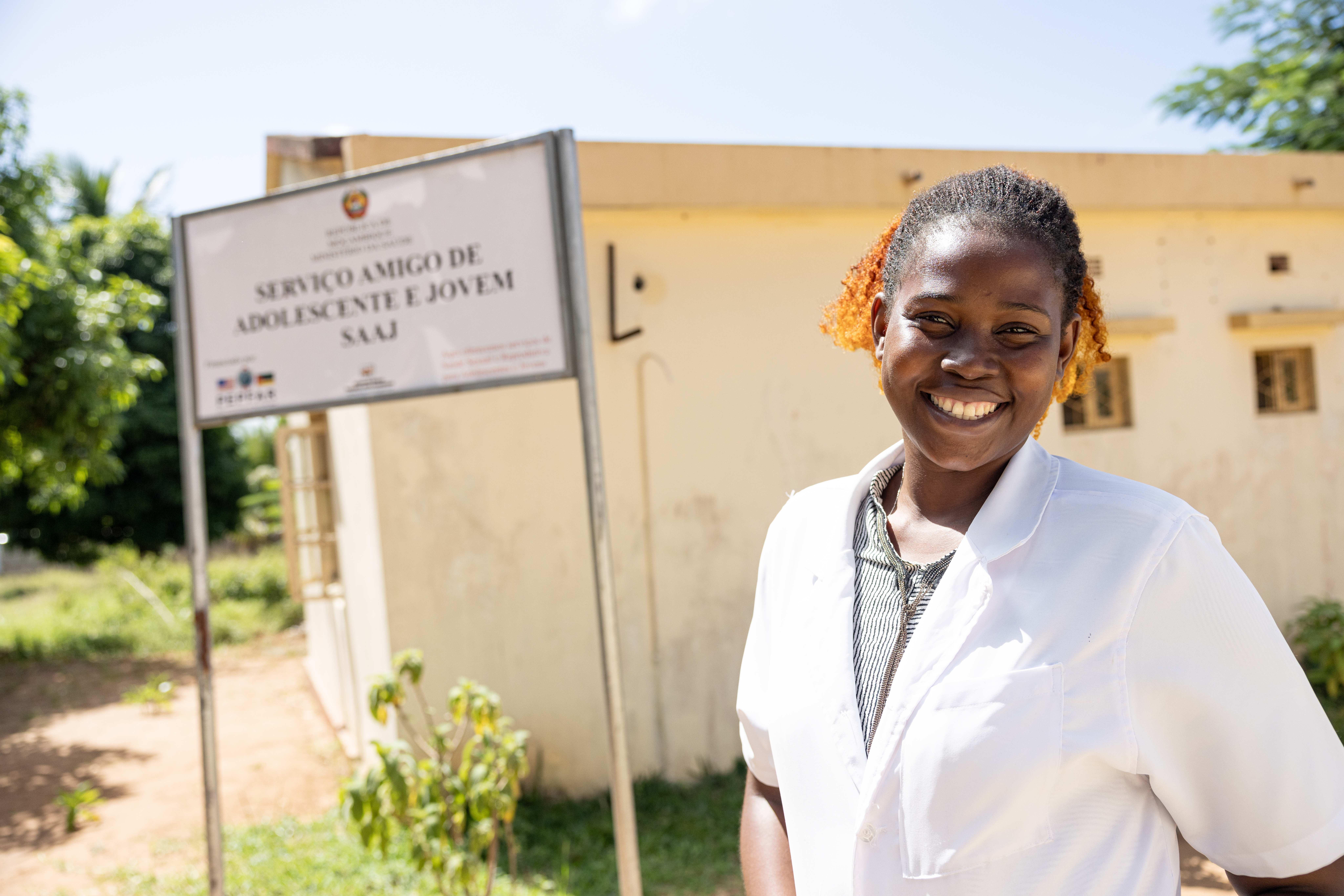 Une infirmière africaine sourit pour une photo devant un centre de santé