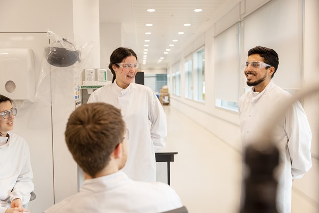 Four scientists talking and laughing together