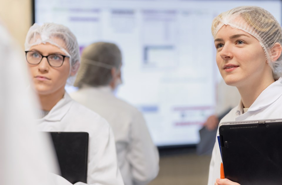 Two female scientists talking with a colleague