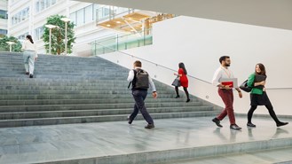 Employees walking up and down the stairs in front of a building