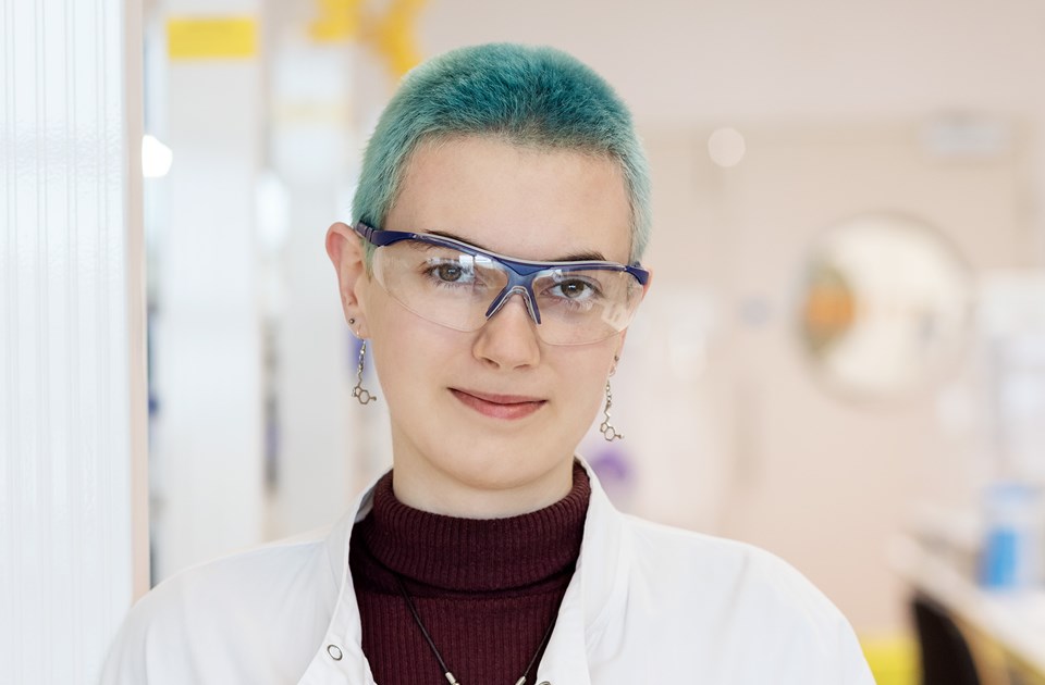 Female employee posing and smiling in a laboratory
