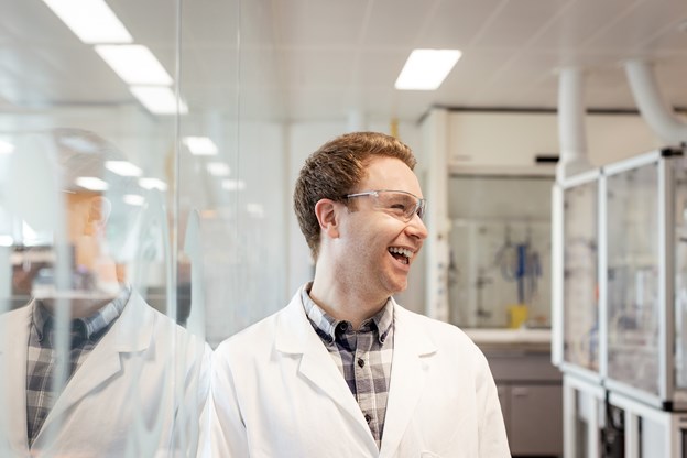 Male employee posing and laughing in a laboratory
