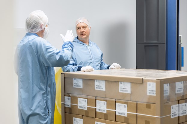 Two employees talking and working together on boxes