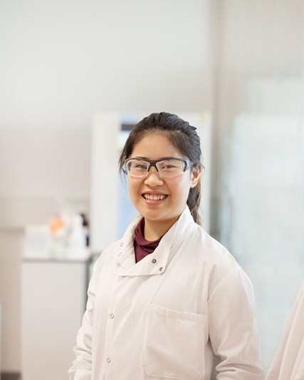 Female employee posing and smiling in a laboratory