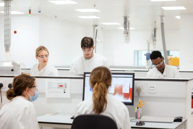 GSK scientists collaborate in a modern Wavre lab, a testament to the team’s dedication to innovation.