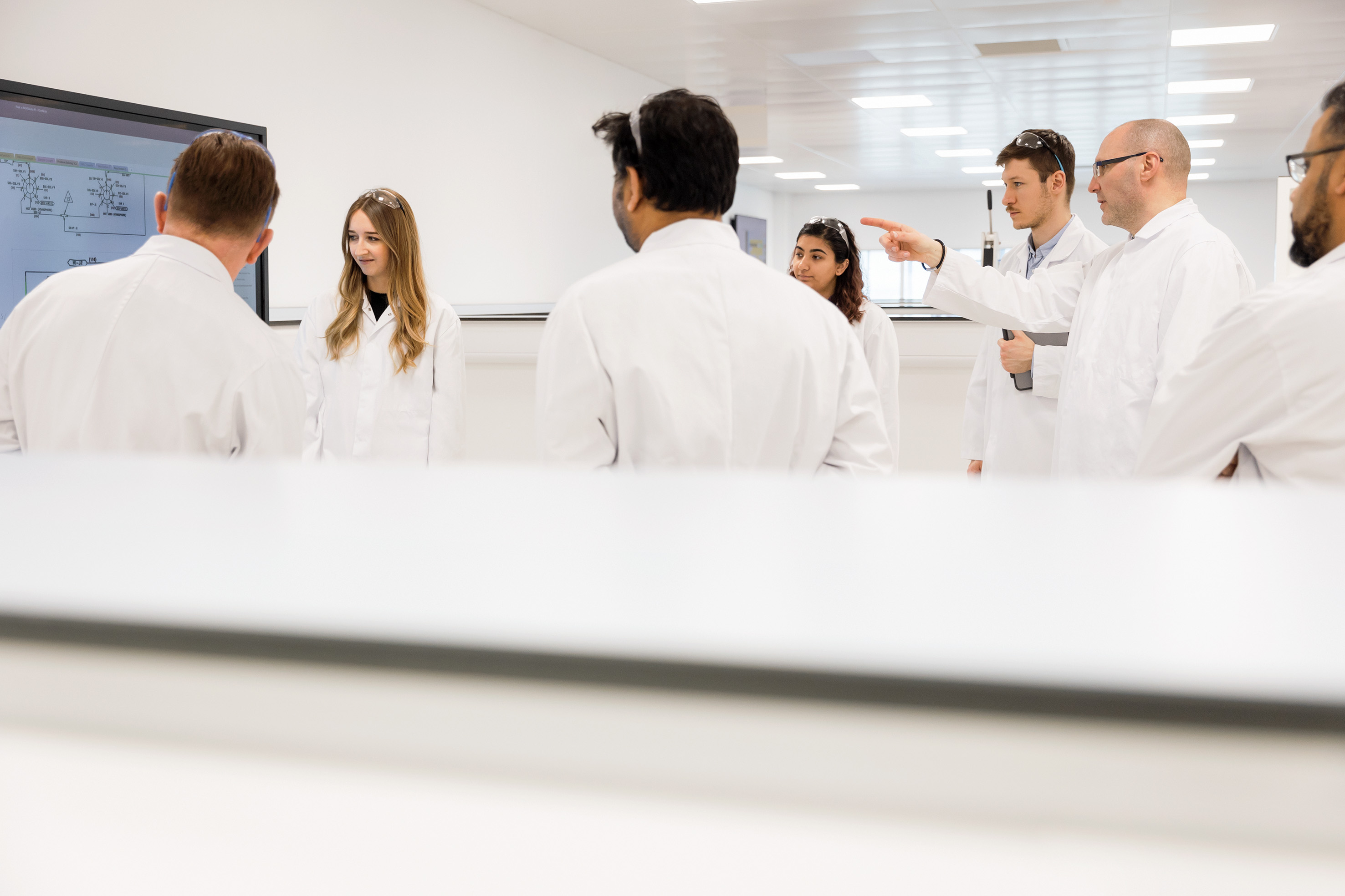 Un groupe de scientifiques regardent un tableau et en discutent