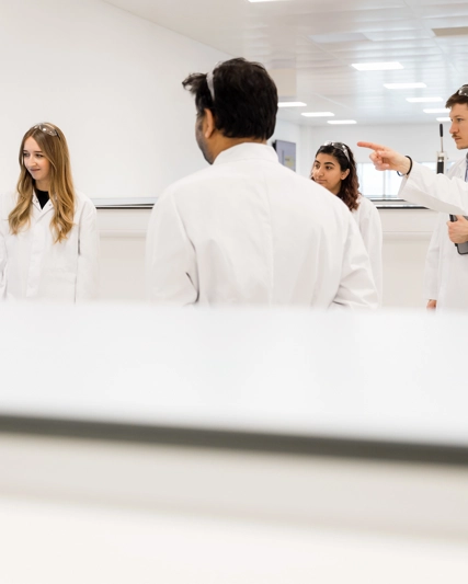 Un groupe de scientifiques regardent un tableau et en discutent