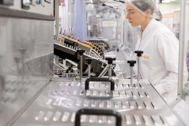 Une scientifique concentrée sur son travail sur une machine en laboratoire