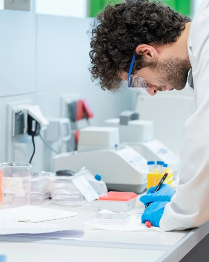 Un scientifique écrit sur une feuille dans un laboratoire