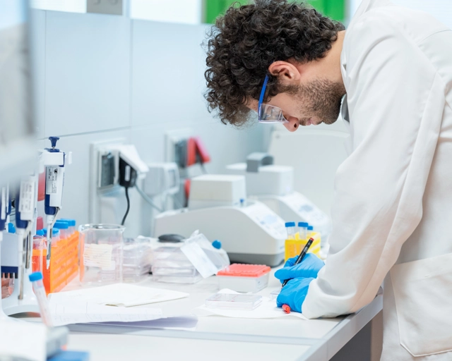 Un scientifique écrit sur une feuille dans un laboratoire