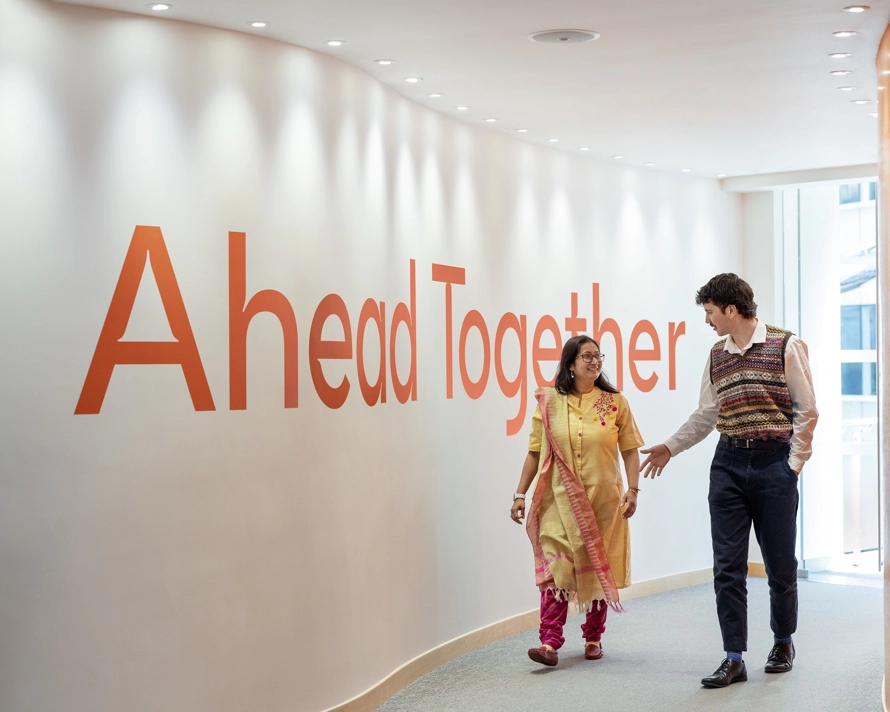 Deux employés marchent un couloir et discutent