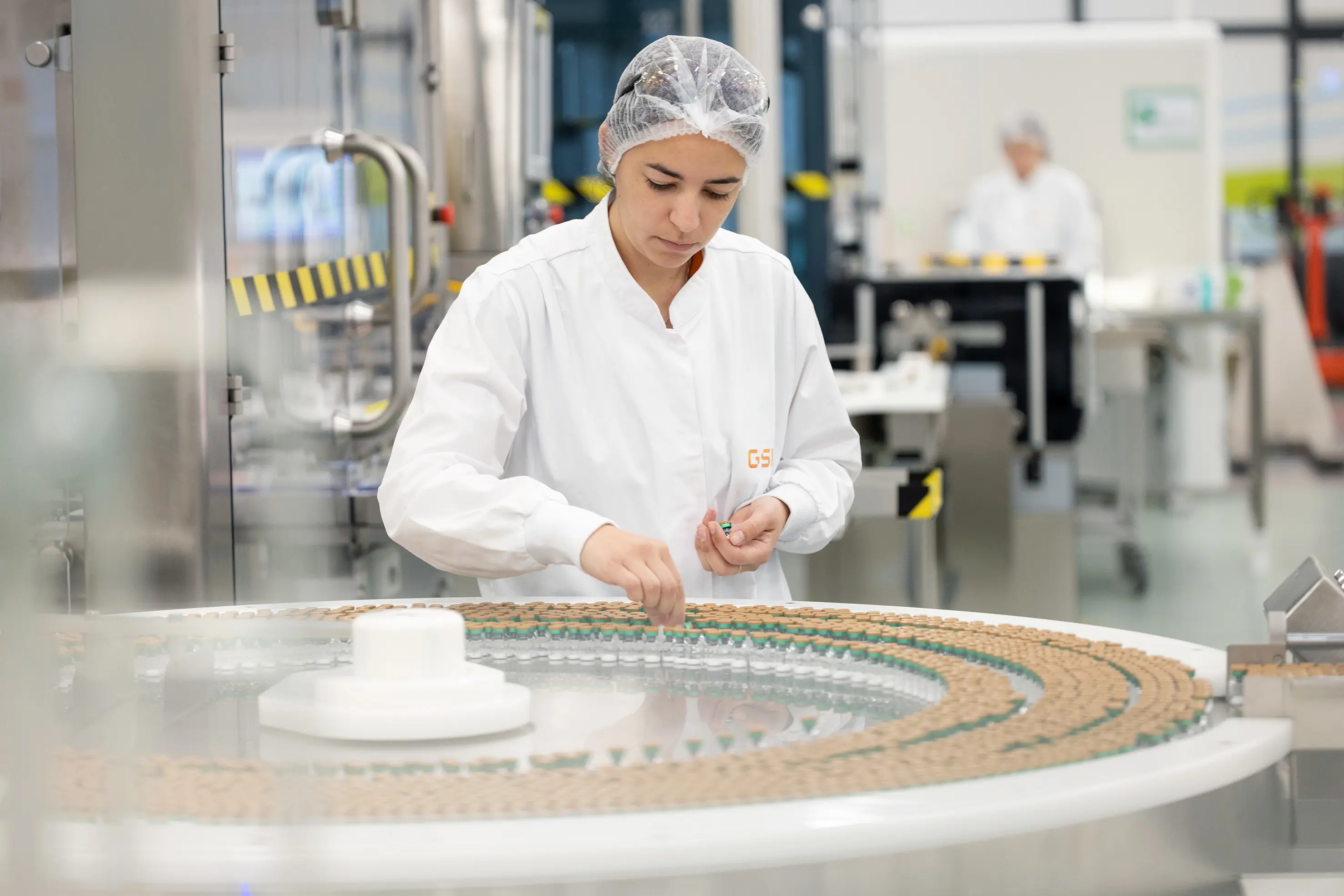 Une scientifique dépose des fioles dans une machine dans un laboratoire