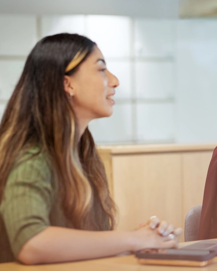 Deux femmes côte à côté à une table discutent