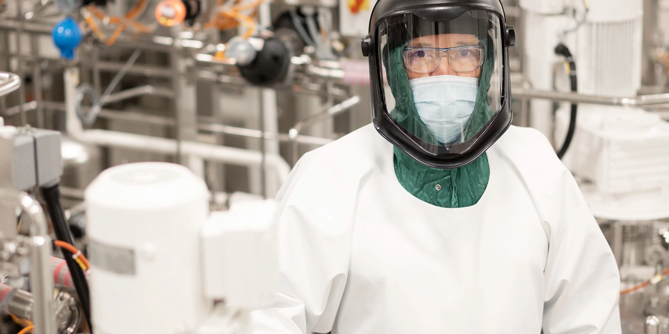 Une femme en combinaison étanche dans un laboratoire