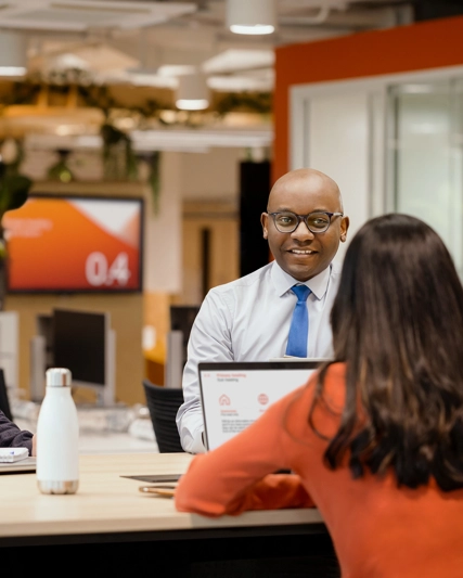 Three employees talking togehter at a desk