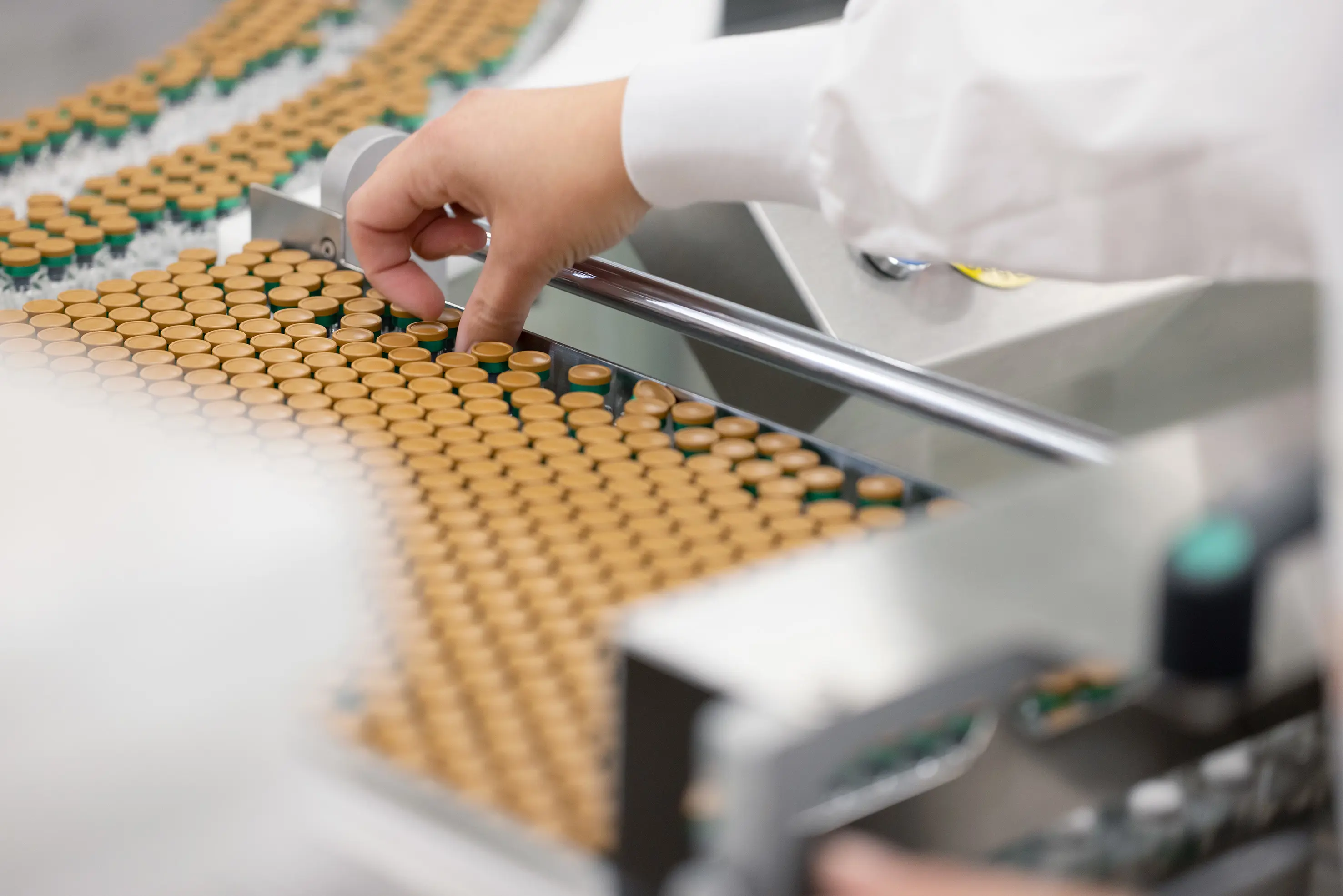 A GSK Wavre employee picking up a vial