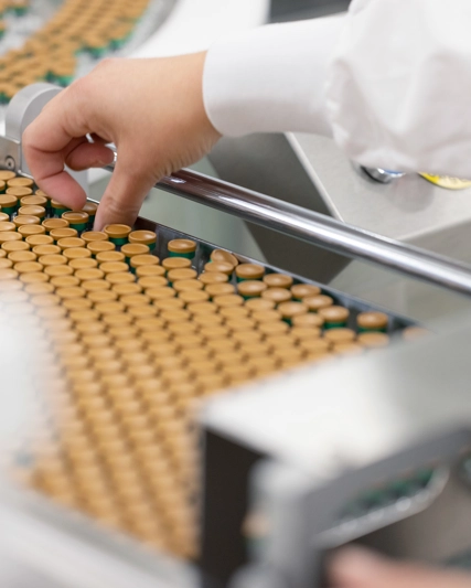 A GSK Wavre employee picking up a vial
