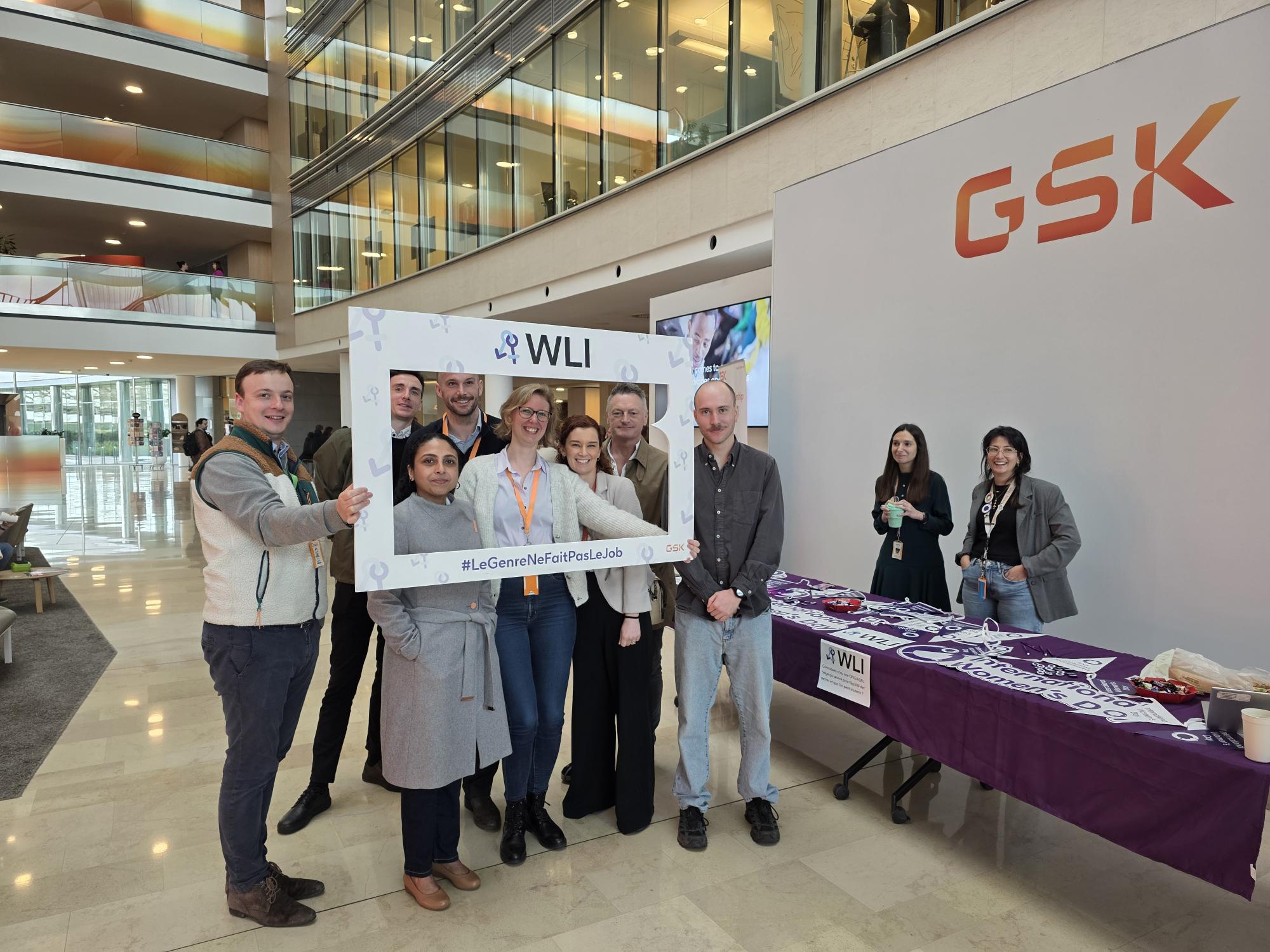 Group of staff members gathered with a WLI photo frame at a GSK office event