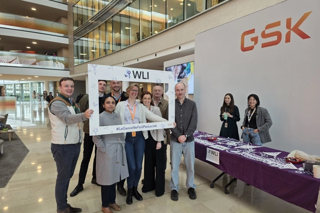 Group of staff members gathered with a WLI photo frame at a GSK office event