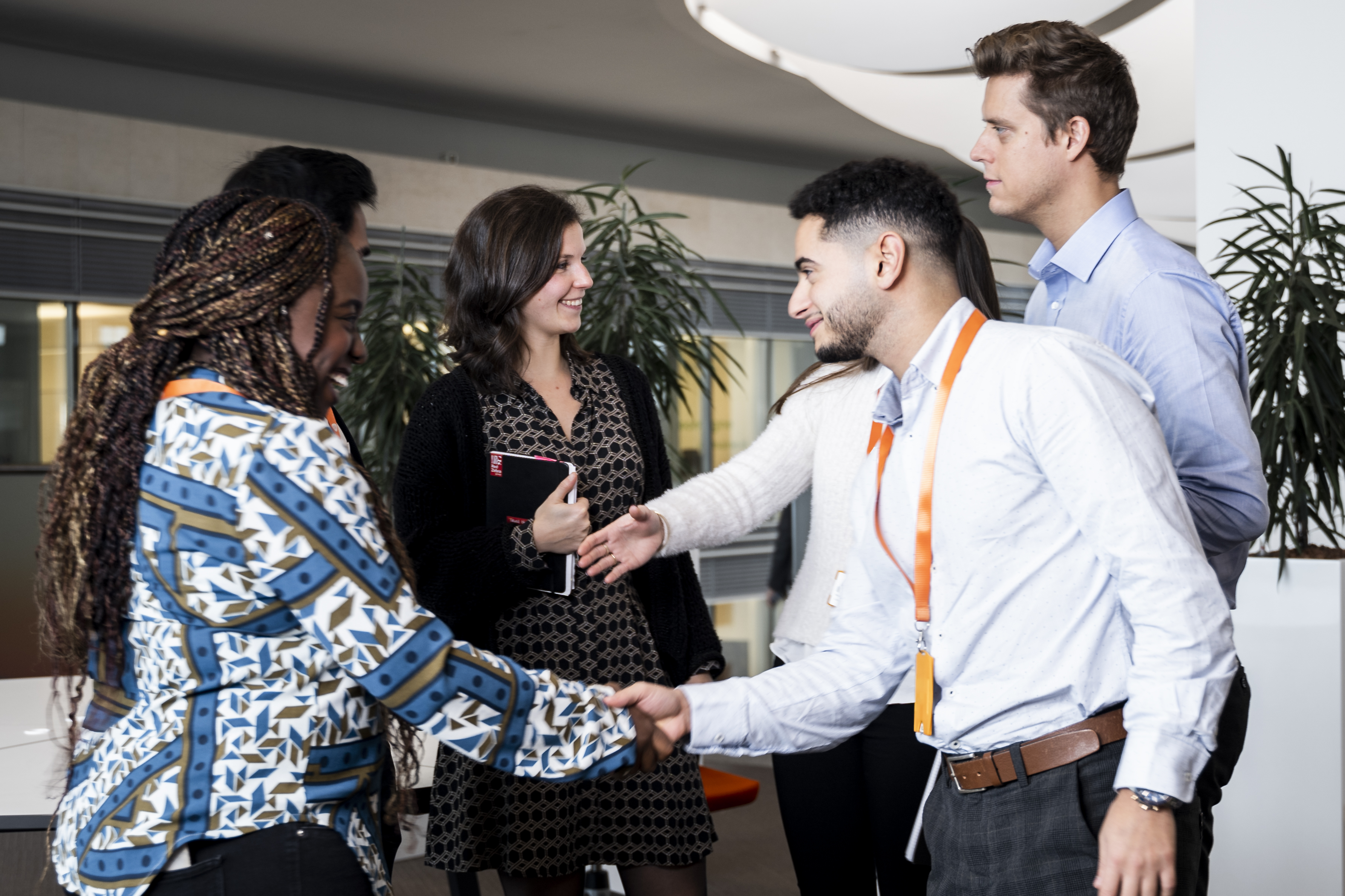Young GSK colleagues meeting and shaking hands