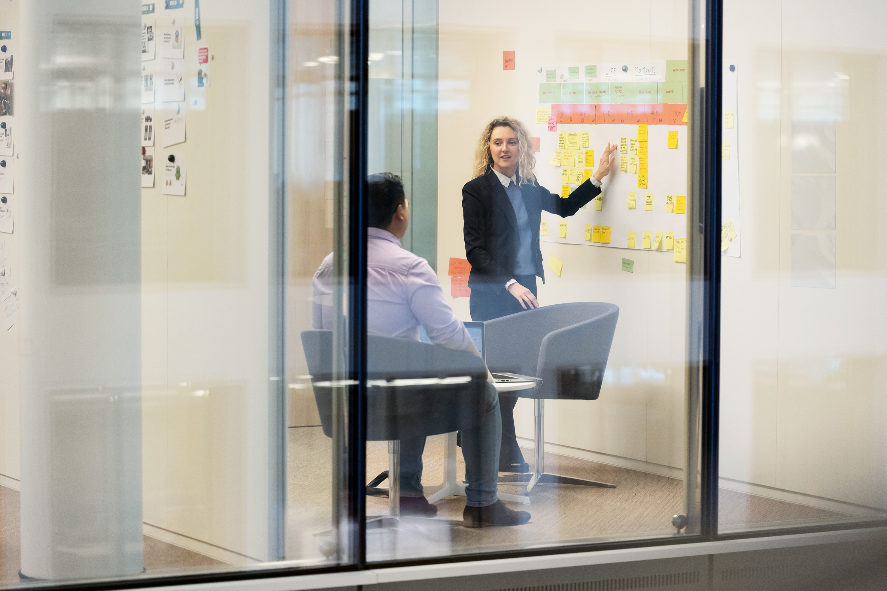 Une femme fait une présentation avec des post-its à son collègue