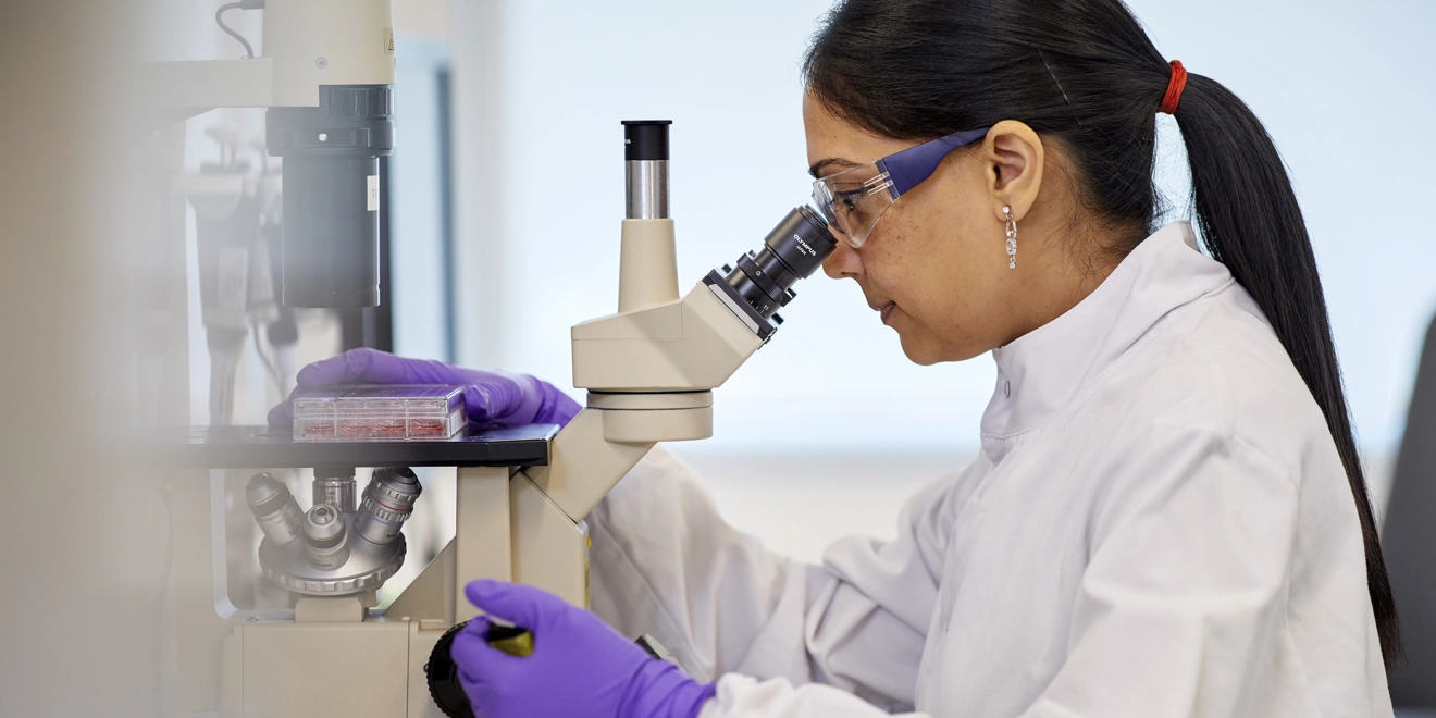 Une jeune scientifique travaillant avec un microscope