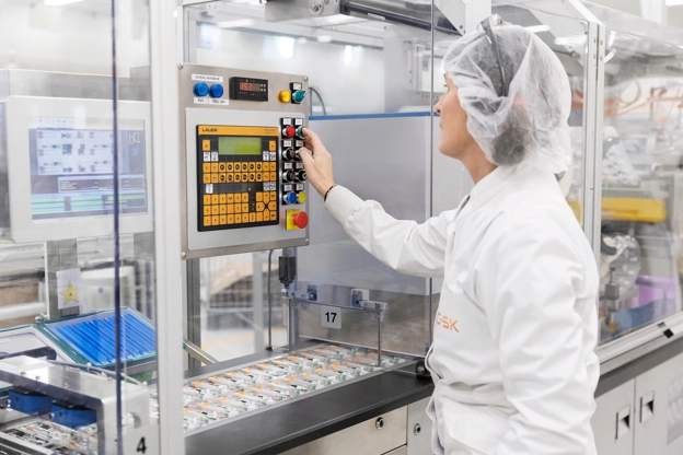 Une scientifique presse un bouton sur un compteur dans un laboratoire