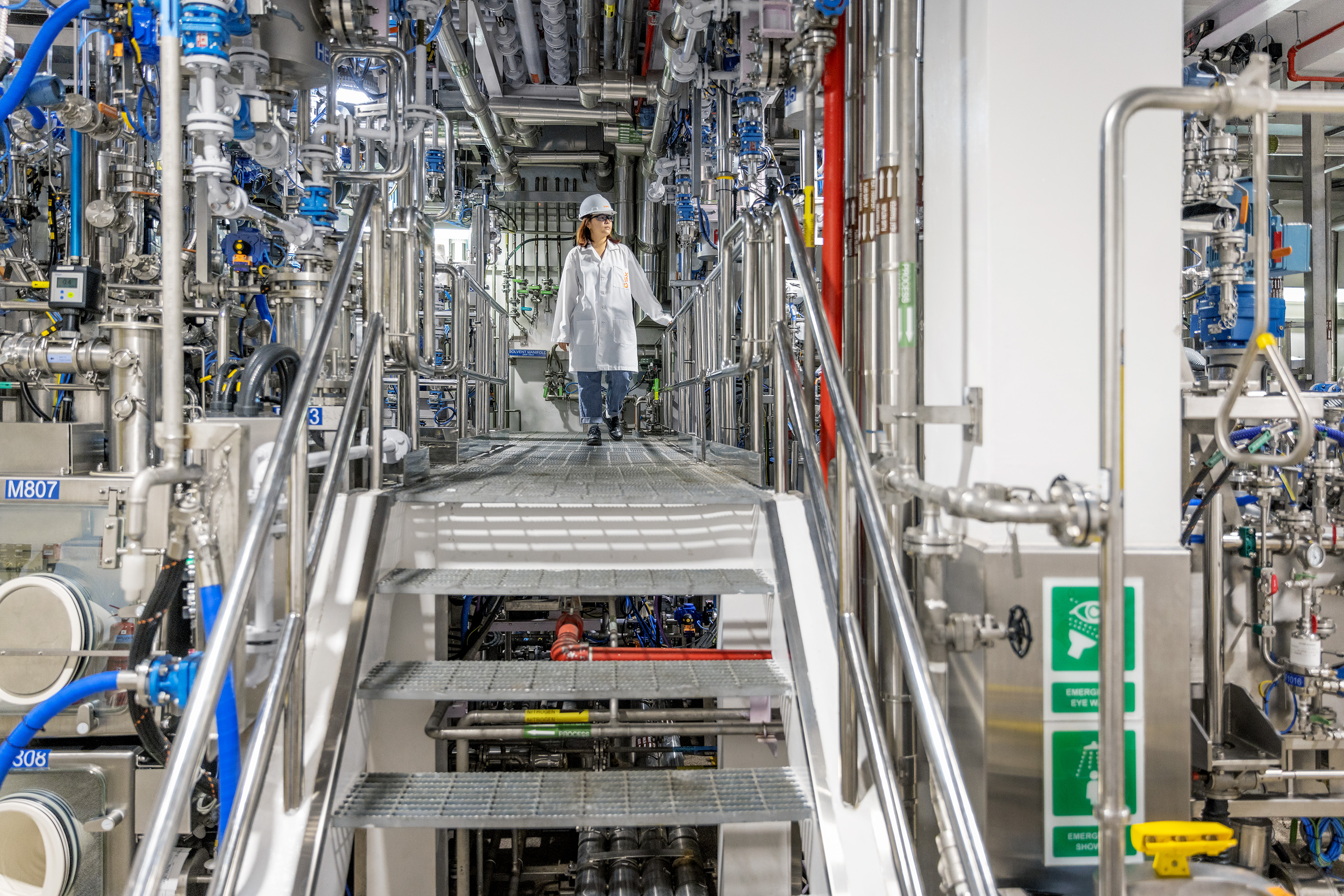 Une scientifique marchant sur une passerelle entre des machines