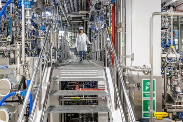 Une scientifique marchant sur une passerelle entre des machines